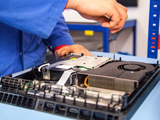 A disassembled PlayStation 4 being serviced by a technician